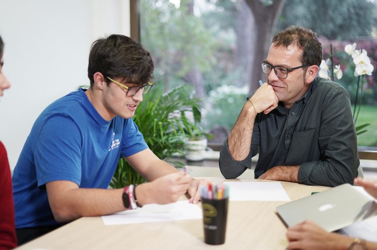 profesor enseñando a un chico en el aula